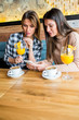 © BGStock72 - Two young female friends sitting in cafe
