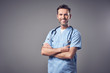 © baranq - Happy doctor in blue uniform smiling isolated