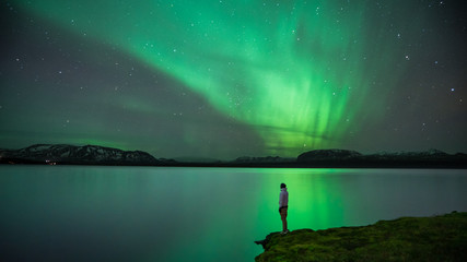 man with northern lights reflection