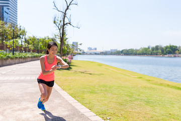 Wall Mural - Sport woman running in the park and using smart watch