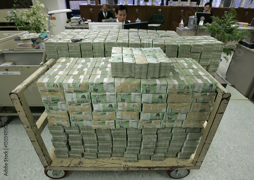 Как выглядит 100 миллиардов долларов Stacks of ten thousand Korean won bills are placed on a cart and a desk at the h