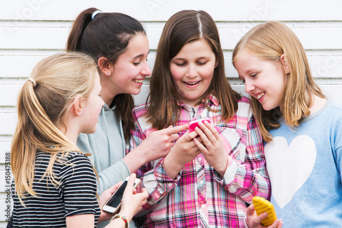 Zdjęcie XXL Grupa młode dziewczyny Outdoors Patrzeje wiadomość Na telefonie komórkowym