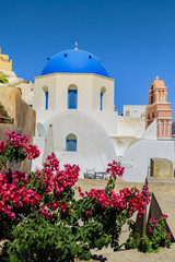 Wall Mural - Picturesque view of Old Town of Oia on the island Santorini, white houses, windmills and church with blue domes, Greece