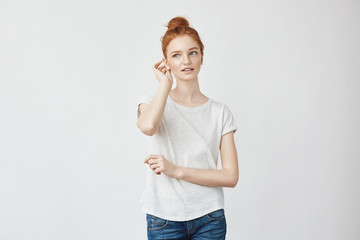 Young beautiful redhead girl smiling correcting hair.