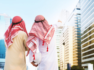 Two arab business man with helmet pointing to building while working on project, teamwork concepts.