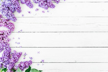 Floral Pattern Made Of Blue Lilac Branches And Petals On White Wooden Background. Flat Lay, Top View. Floral Purple Frame