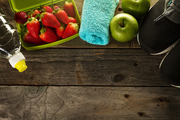 Healthy Life Sport Concept. Sneakers with Apples, Towel and Bottle of Water on Wooden Background. Copy Space.