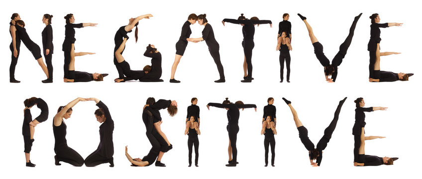 Black dressed people forming NEGATIVE POSITIVE