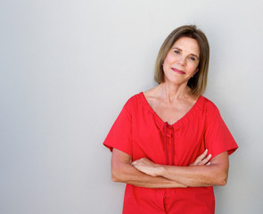 Wall Mural - beautiful older woman with arms crossed against gray background