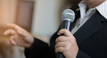 Blurred Of Businesswoman Speech With Microphone, Hand Gesturing Protesting Or Belief Concept For Explaining