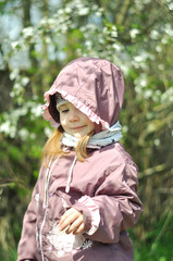 Adorable little girl in blooming cherry garden on beautiful spring day