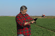 © sima - Agriculture, farmer examining wheat plant in field using tablet