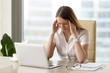 © fizkes - Businesswoman under terrible physical tension at work. Female entrepreneur with head ache sitting at desk in front of laptop, massaging temples. Stressed young girl on the edge of a nervous breakdown