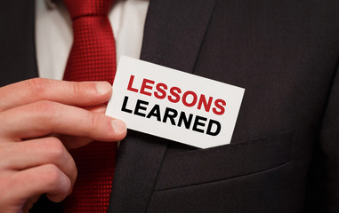 Aufkleber - Businessman putting a card with text LESSONS LEARNED in the pocket