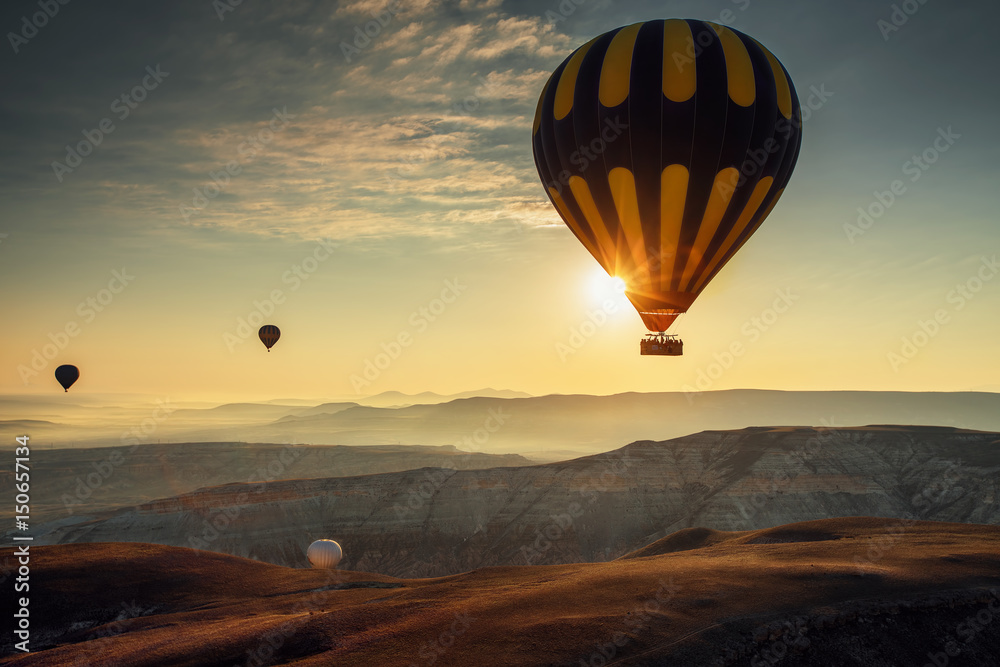 Hot air balloons flying over the valley at Cappadocia.