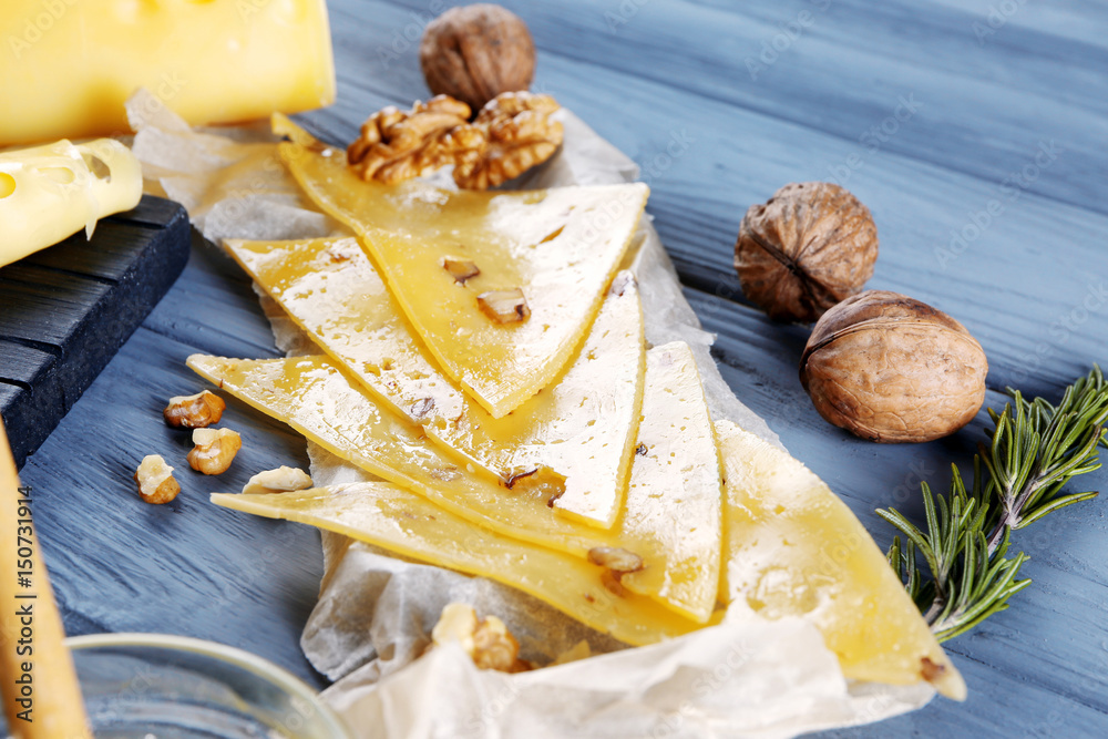 Sliced hard cheese on wooden background