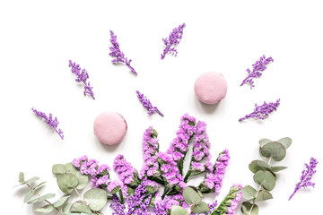  lady morning with macaroons and mauve flowers white desk background top view