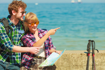 couple backpacker with map by seaside