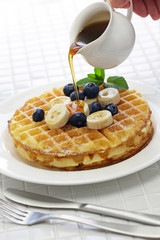 Wall Mural - pouring maple syrup over homemade american round waffles
