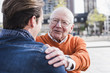 © Westend61 - Smiling senior man looking at adult grandson outdoors