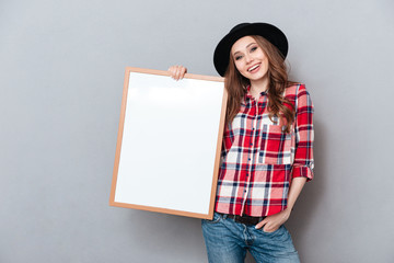 Poster - Portrait of a happy smiling young woman in plaid shirt