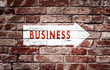 © robsonphoto - Business arrow sign on aged brick wall background. Conceptual company direction symbol.