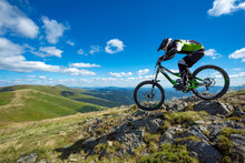 A Man Is Riding Bicycle, On The Background Of Mountains And Blue Sky. Beautiful Summer Day.