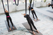 © Kateryna Muzhevska - Young women doing aerial yoga exercise
