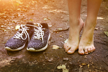 Wall Mural - bare feet and shoes on forest path