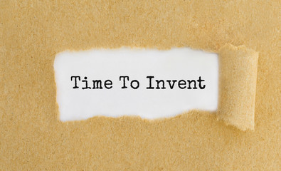 Poster - Text Time To Invent appearing behind ripped brown paper