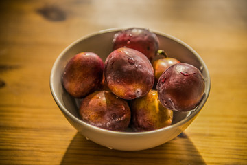 Wall Mural - Ripe plums on wood table