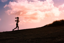 Silhouette Of Female Running Up A Hill. 