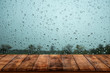 Wood table with rain water drop on window.