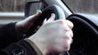 © kirill4mula - Driver's hands on the steering wheel closeup. Highway and urban traffic and driving scene.
