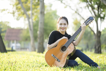 Young attractive woman playing acoustic guitar