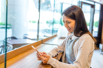 Canvas Print - Woman working on mobile phone in coffee shop