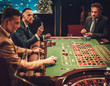© Nejron Photo - Upper class friends gambling in a casino