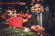 © Nejron Photo - Upper class man behind gambling table in a casino