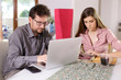 © fabianaponzi - Young couple working at home with technology medium shot
