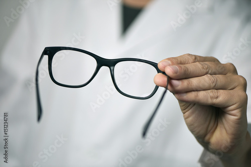 Fotomural optician man bringing a pair of eyeglasses