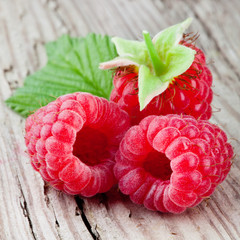 Canvas Print - Raspberry. Fresh organic berries with leaves macro. Fruit on wooden background.
