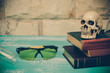 safety eye glasses and skull on old book