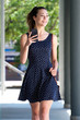 © mimagephotos - cool young woman in dress walking in city with cellphone