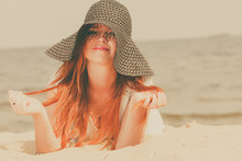 Redhead Woman Wearing Sun Hat Lying On Beach