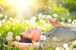 © Subbotina Anna - Beautiful young woman lying on the field in green grass and blowing dandelion