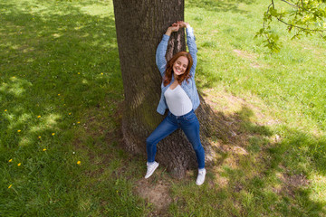 Wall Mural - frau steht im park und streckt die arme nach oben