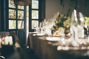 Wall Mural - Wedding. Banquet. Table for guests, decorated with candles and flowers, served with cutlery and crockery and covered with a tablecloth. Restaurant entrance with opened door