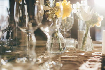 Wall Mural - Wineglasses at sunset. Wedding banquet. Table for guests, decorated with candles and flowers, served with cutlery and crockery and covered with a tablecloth. Table decorated for the wedding reception