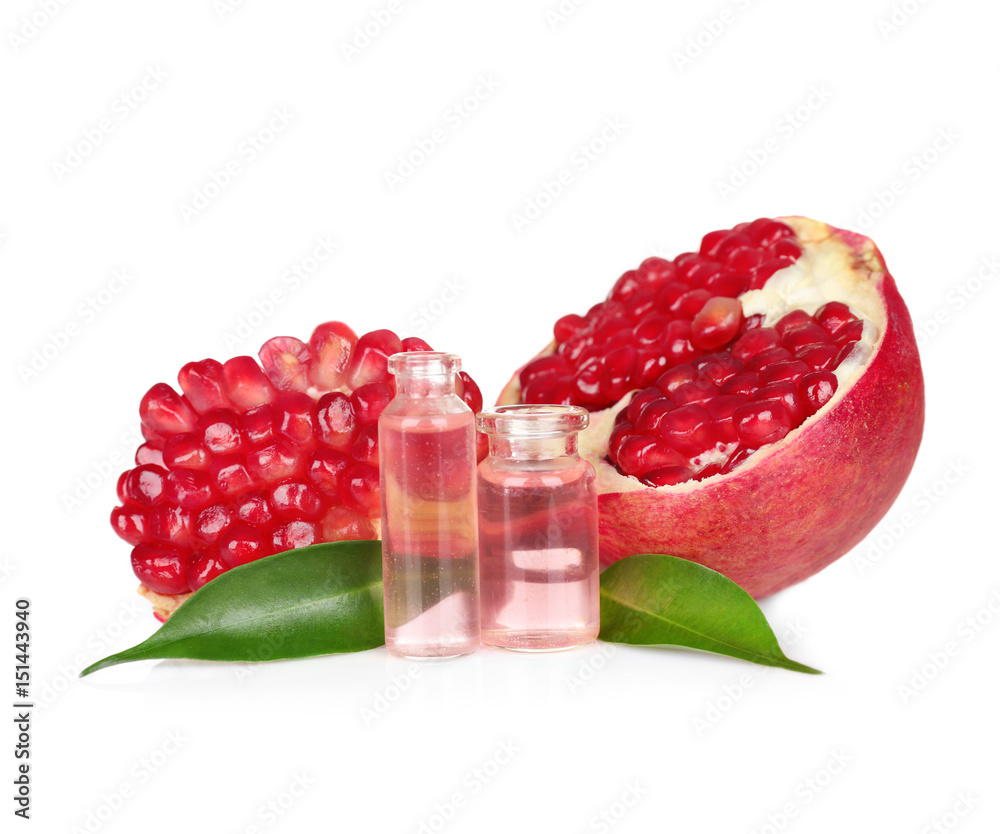 Perfume bottles and pomegranate on white background