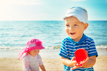 Wall Mural - Babygirl and babyboy playing on the beach